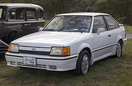 1990_Ford_Escort_GT_in_white,_front_left_(Hershey_2019).jpg