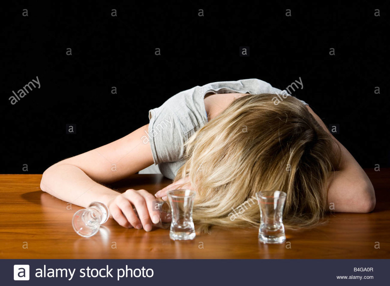 a-young-woman-passed-out-drunk-on-a-bar-counter-B4GA0R.jpg