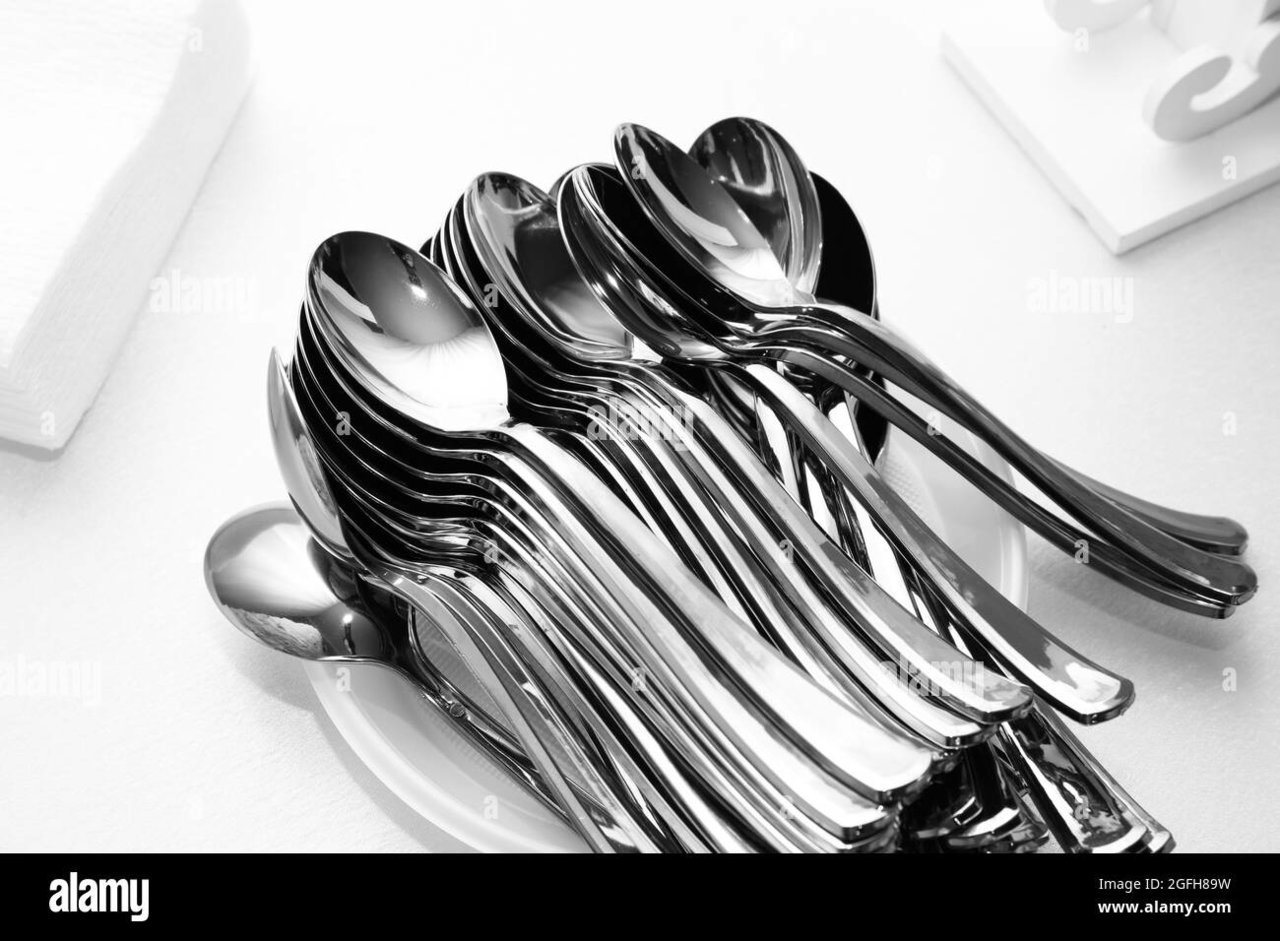 many-spoons-on-pile-of-plates-2GFH89W.jpg